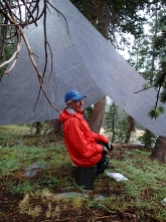 A Room With A View: Karen hanging out under the tarp, hoping the rain will relent so she can hang a hammock under it.